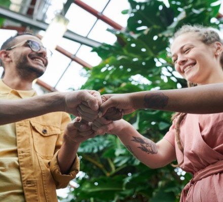 man and woman touching hands in greenhouse